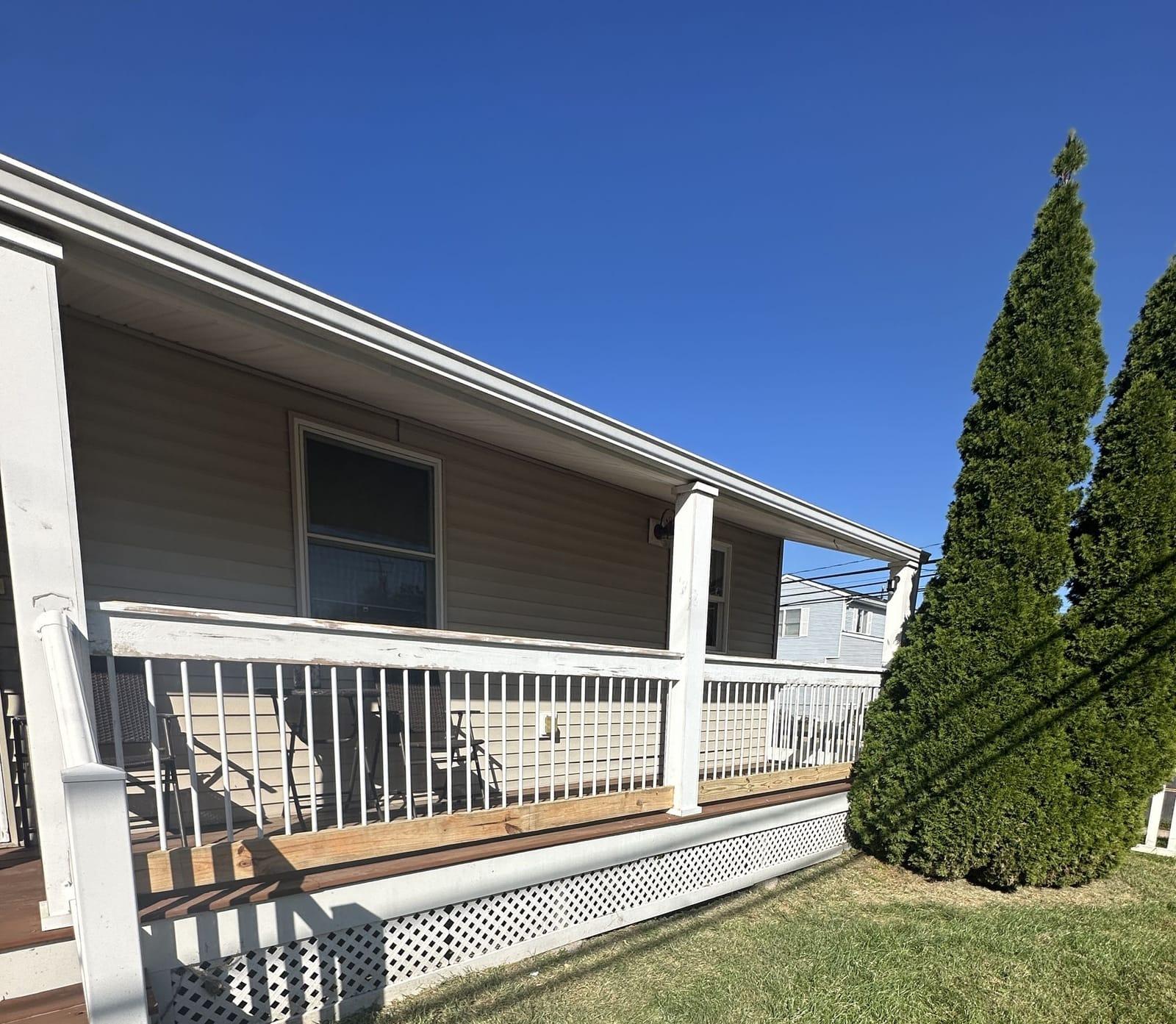 New pressure-treated top cap fitted on porch railing during restoration