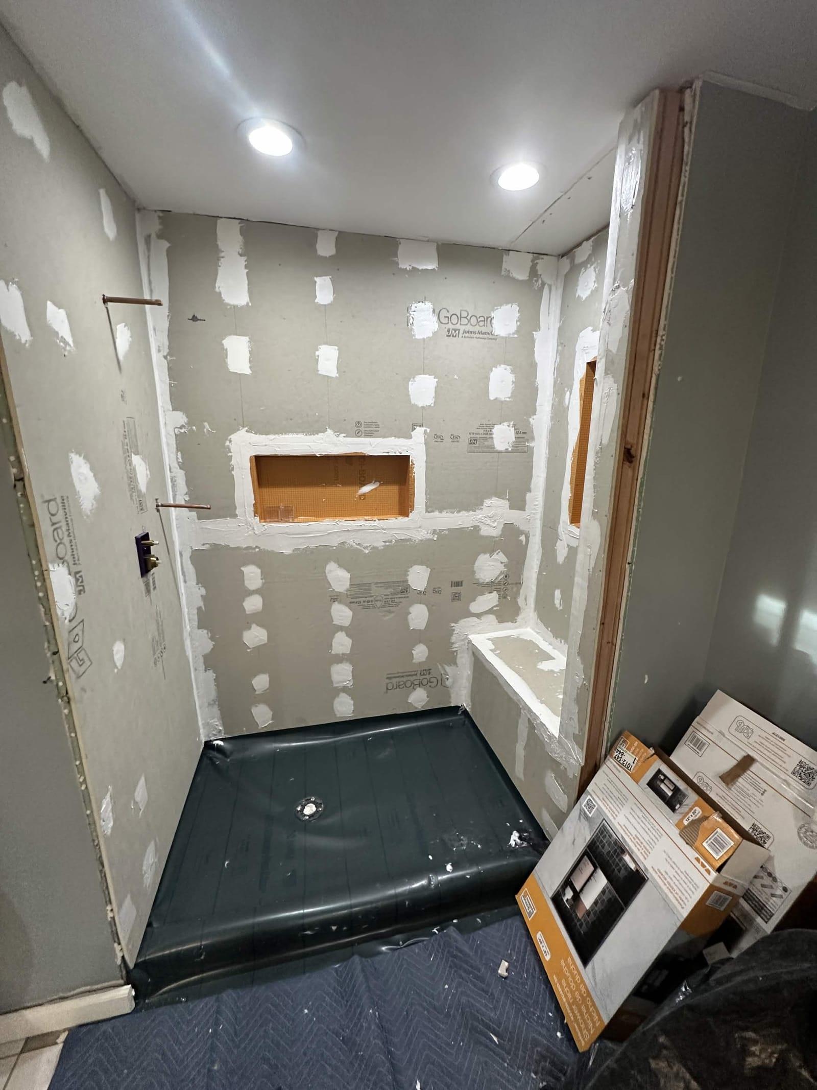 Documented shower waterproofing: sealed backer board, pan liner, niche, and bench before tile